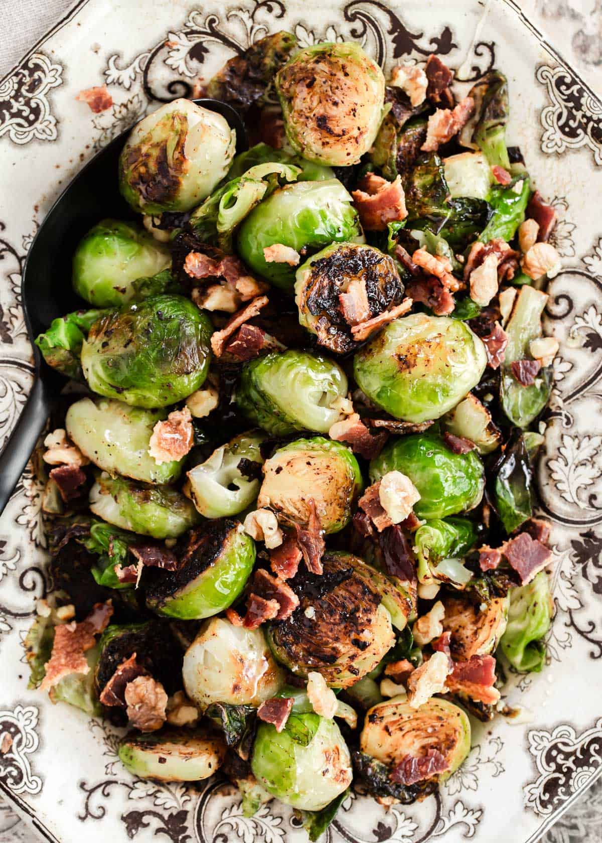 brussels sprouts with bacon and nuts served in vintage dish.