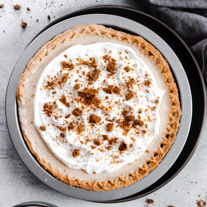 ice cream pie topped with whipped cream and crushed cookies.