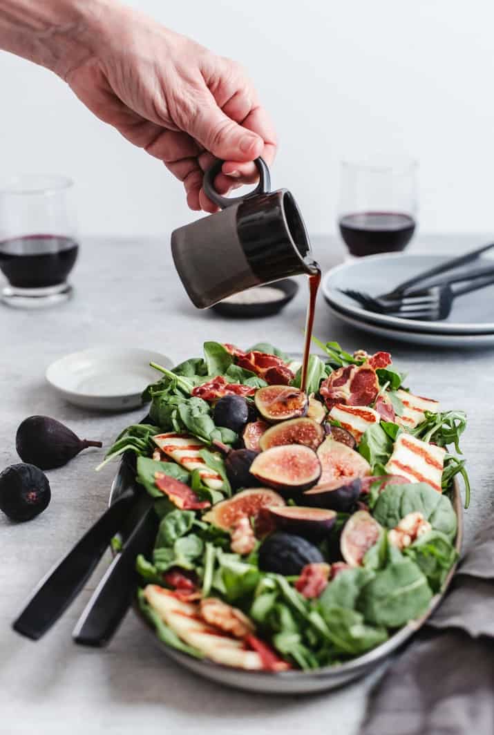 pouring dressing on fall fig salad 