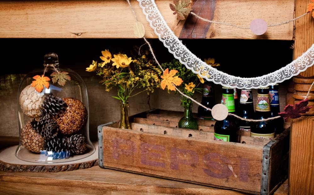 wood table shelf with vintage bottle crate filled with cider.