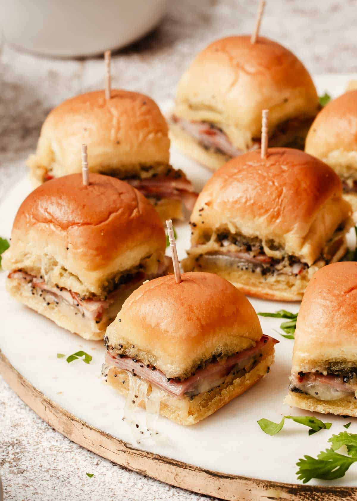 Platter of mini party sandwiches on white tray.