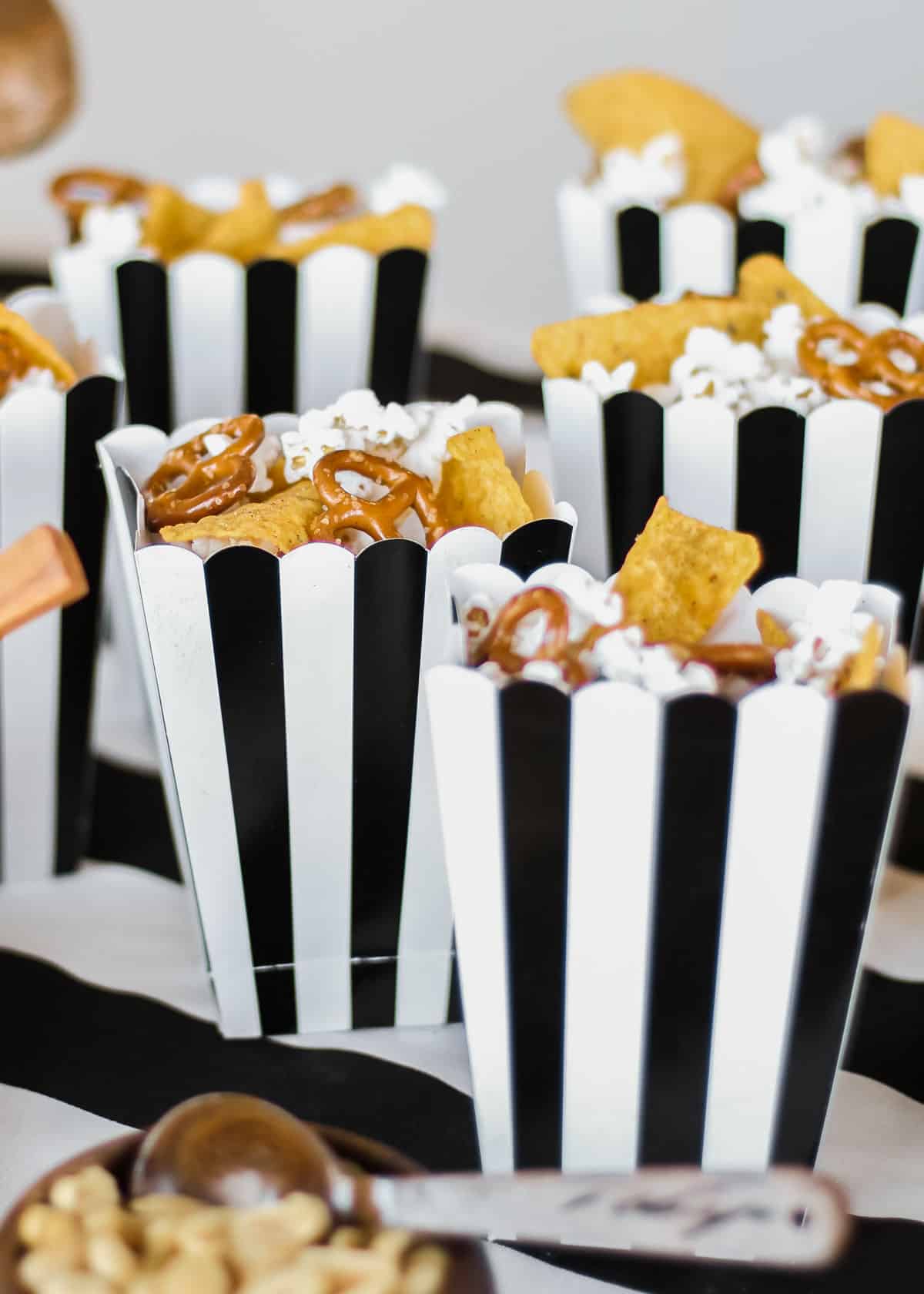 black and white stripe snack boxes filled with popcorn, pretzels, and Doritos.