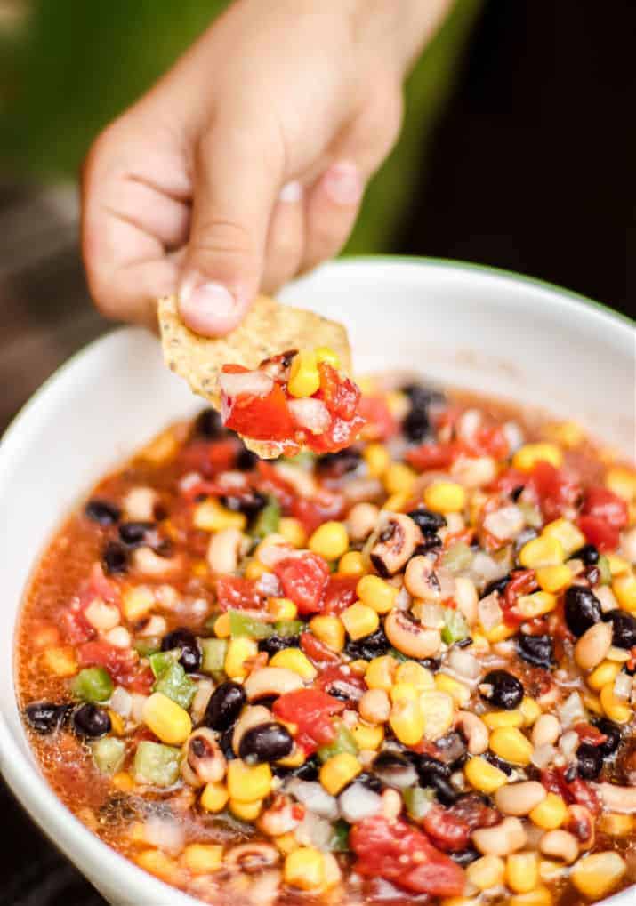 bean and corn salsa with chip dipped in