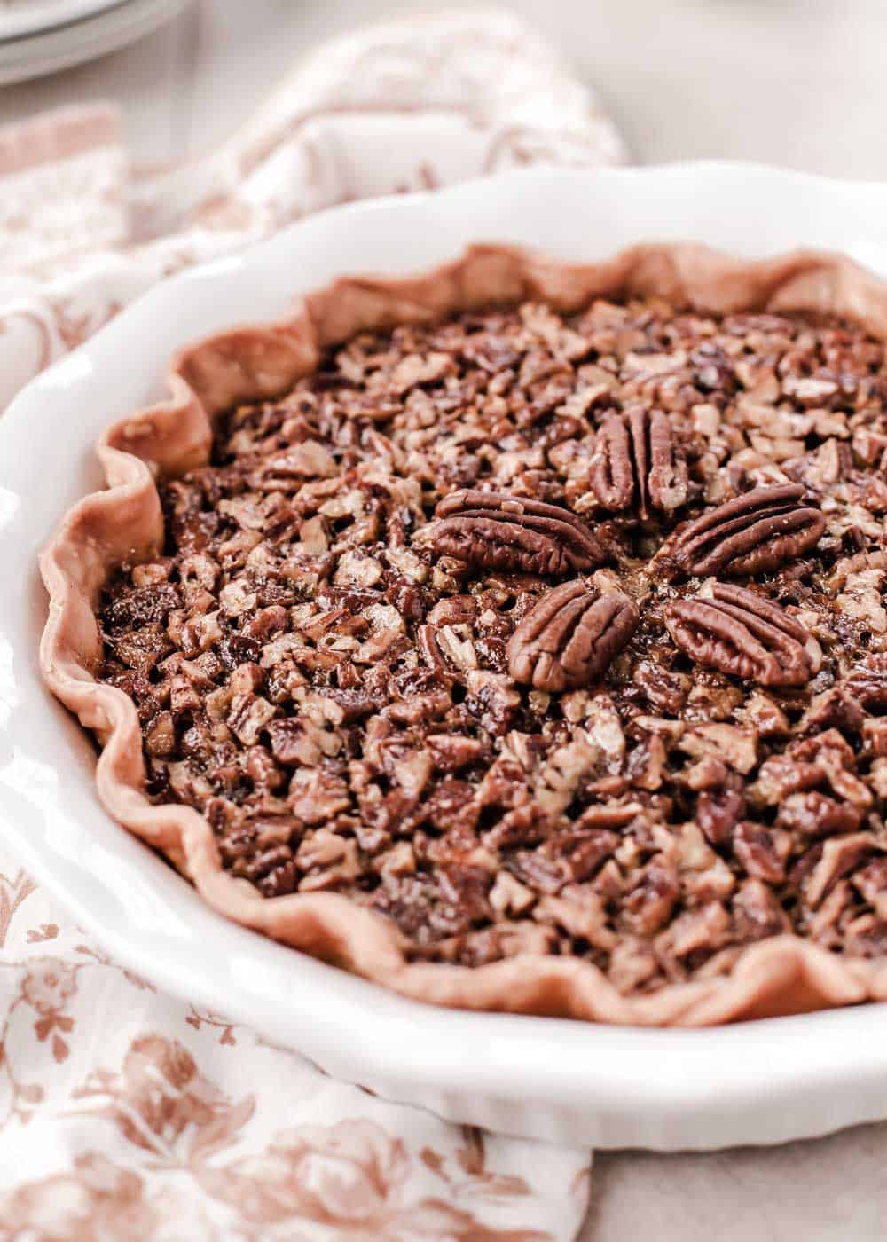 side view of pecan pie in white dish.