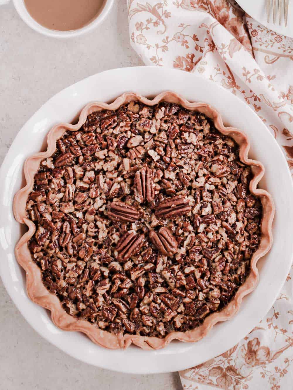 whole pecan pie in white dish.