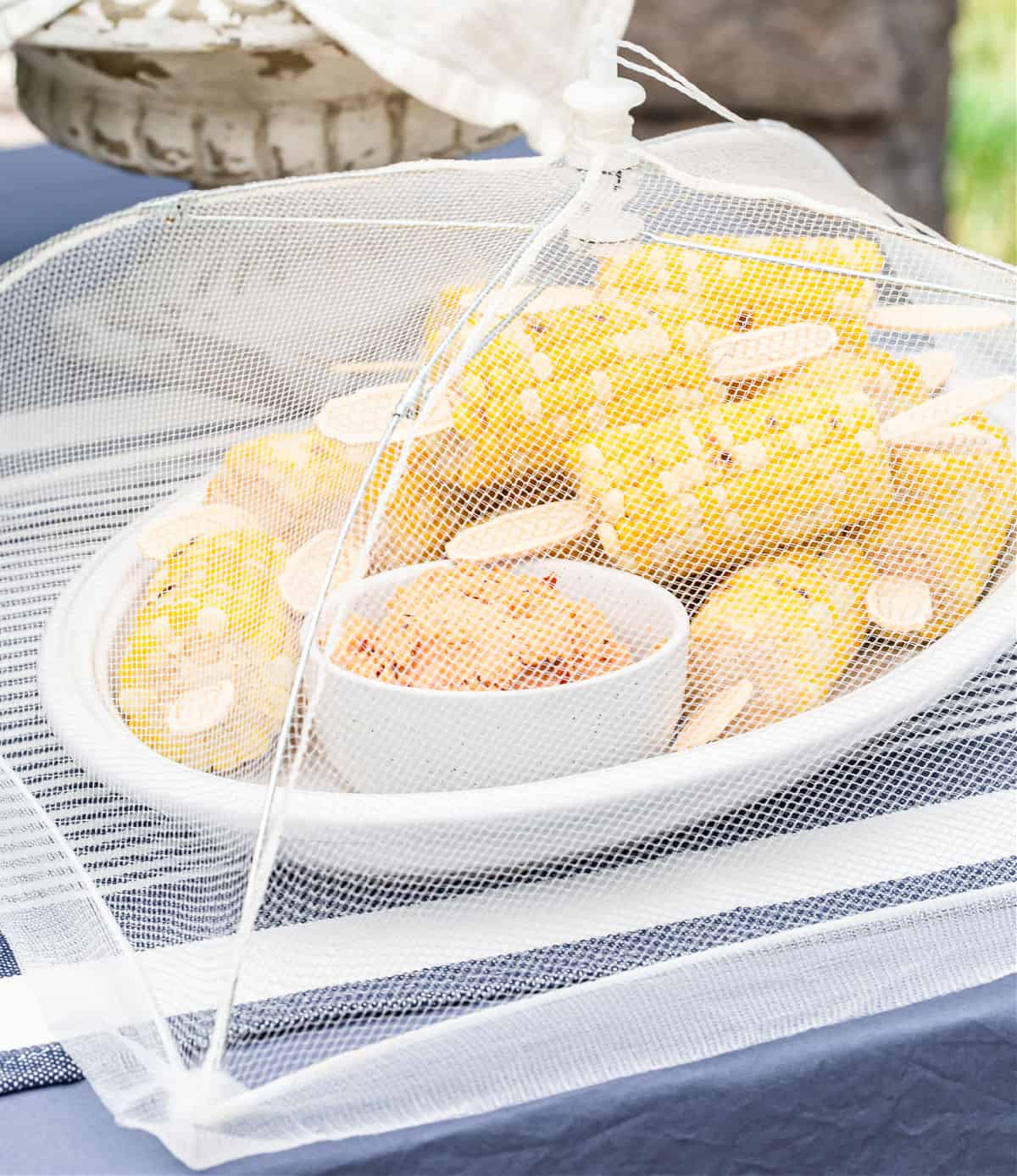 corn on the cob under white food umbrella, for a party