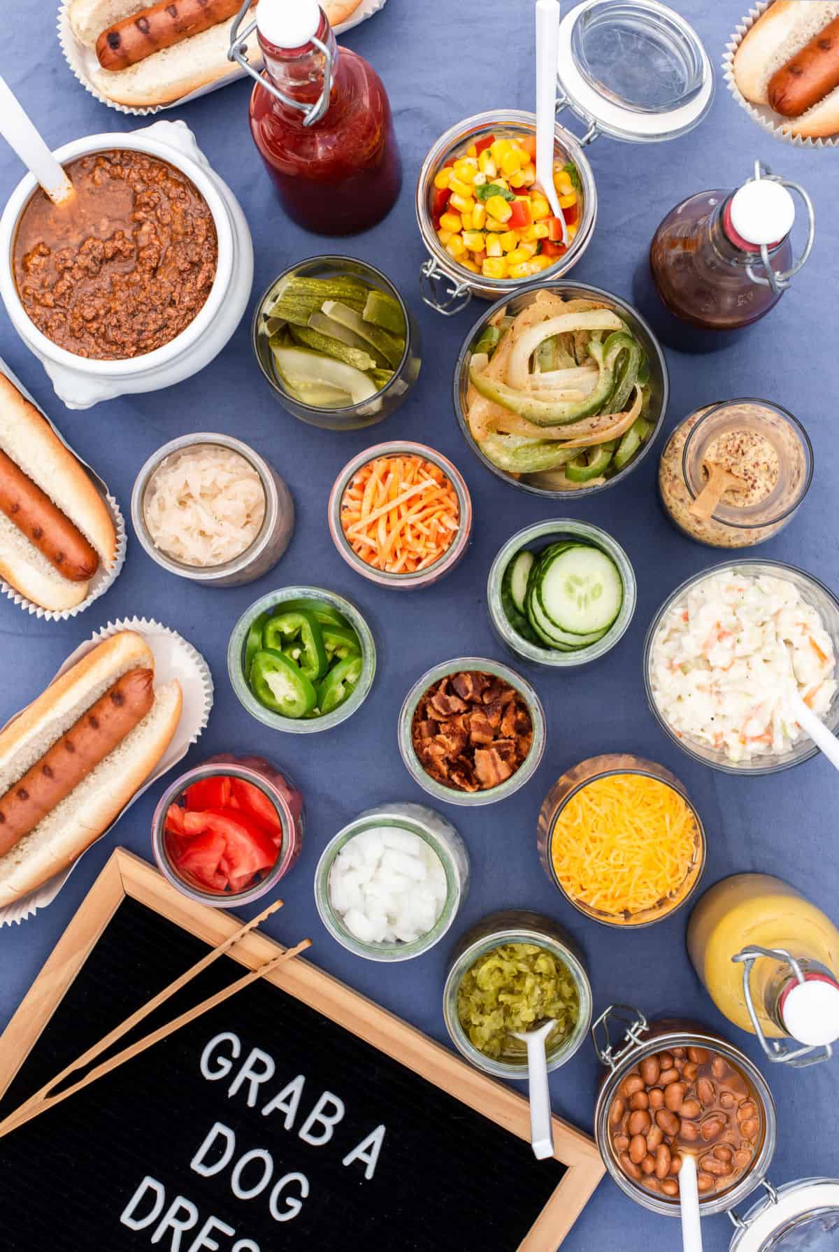 overhead view of hot dogs and all the toppings in jars
