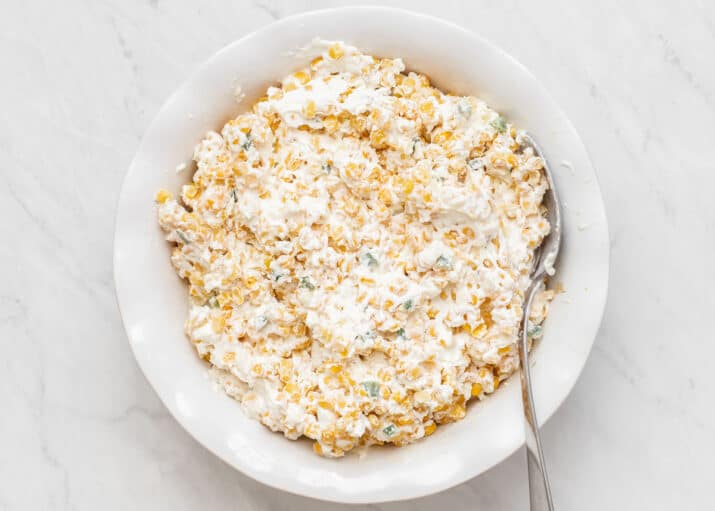 ingredients all combined in white dish, for corn dip.