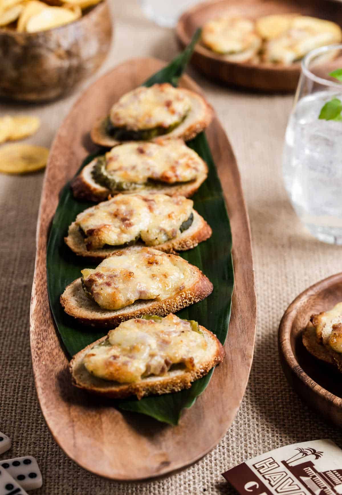 Cubano tapas on wood tray lined with tropical leaf.