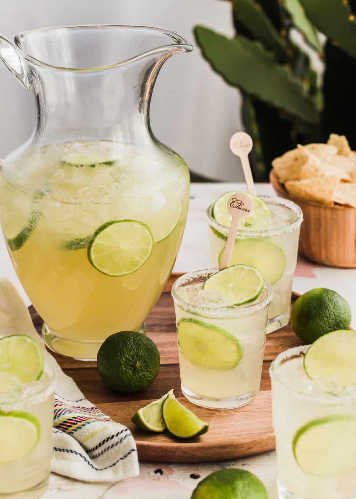 pitcher of beer margaritas with filled glasses surrounding it.