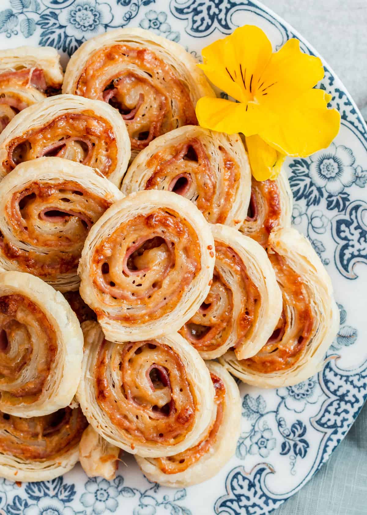 puff pastry spirals on blue and white plate, overhead.