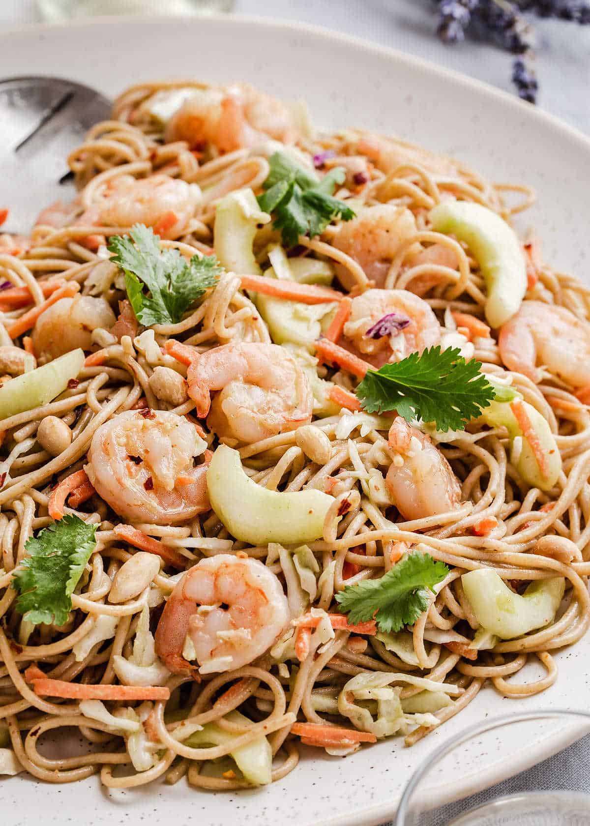 cold spaghetti pasta salad with shrimp on white platter.