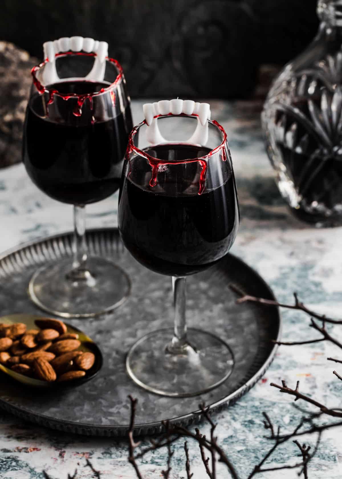 red wine in glasses with blood red rim and vampire teeth on the side.