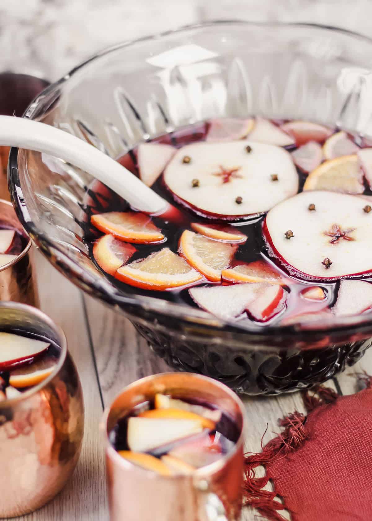 thanksgiving sangria with apples and lemons floating on top, in punch bowl.