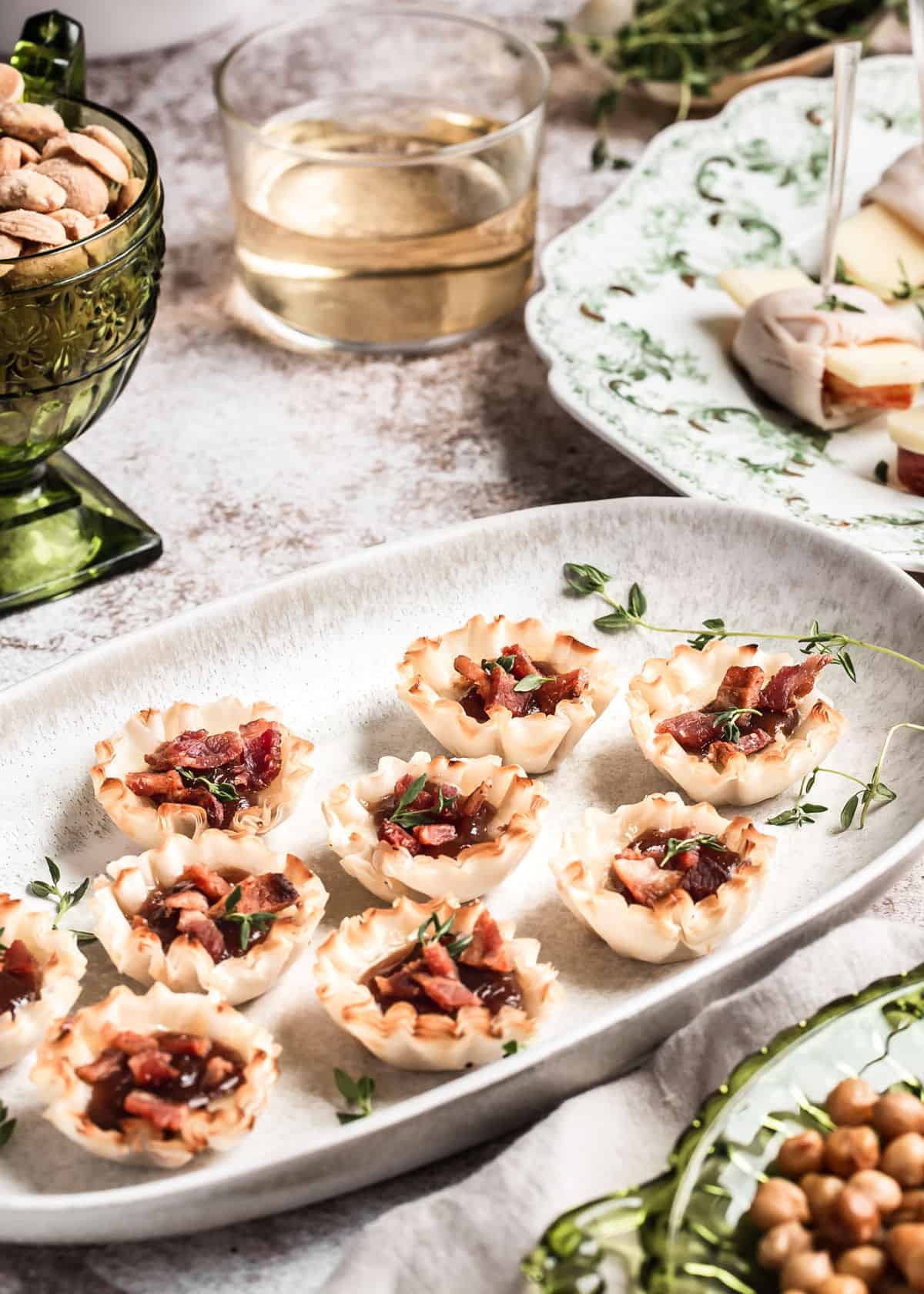 appetizer table with tray of phyllo cups with bacon bits on top.