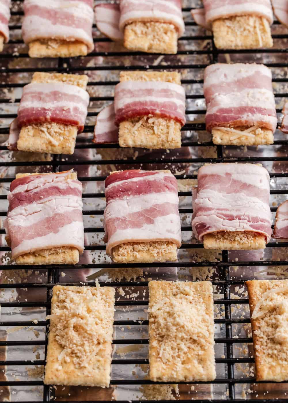 bacon wrapped club crackers on baking rack ready to be cooked.