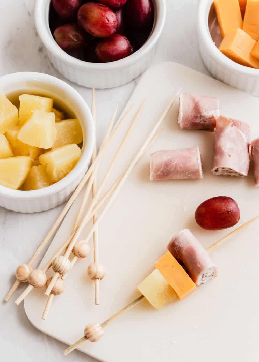 example of how to make fruit and cheese and ham on wooden skewers.