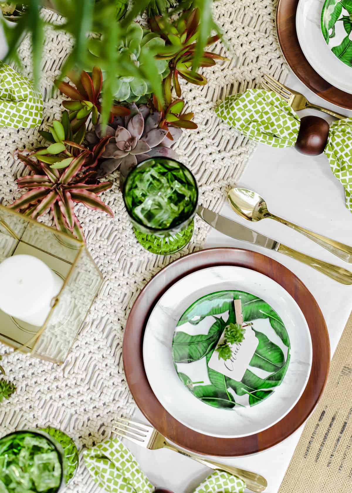 overhead view of tropical place setting on green and cream color dinner table.