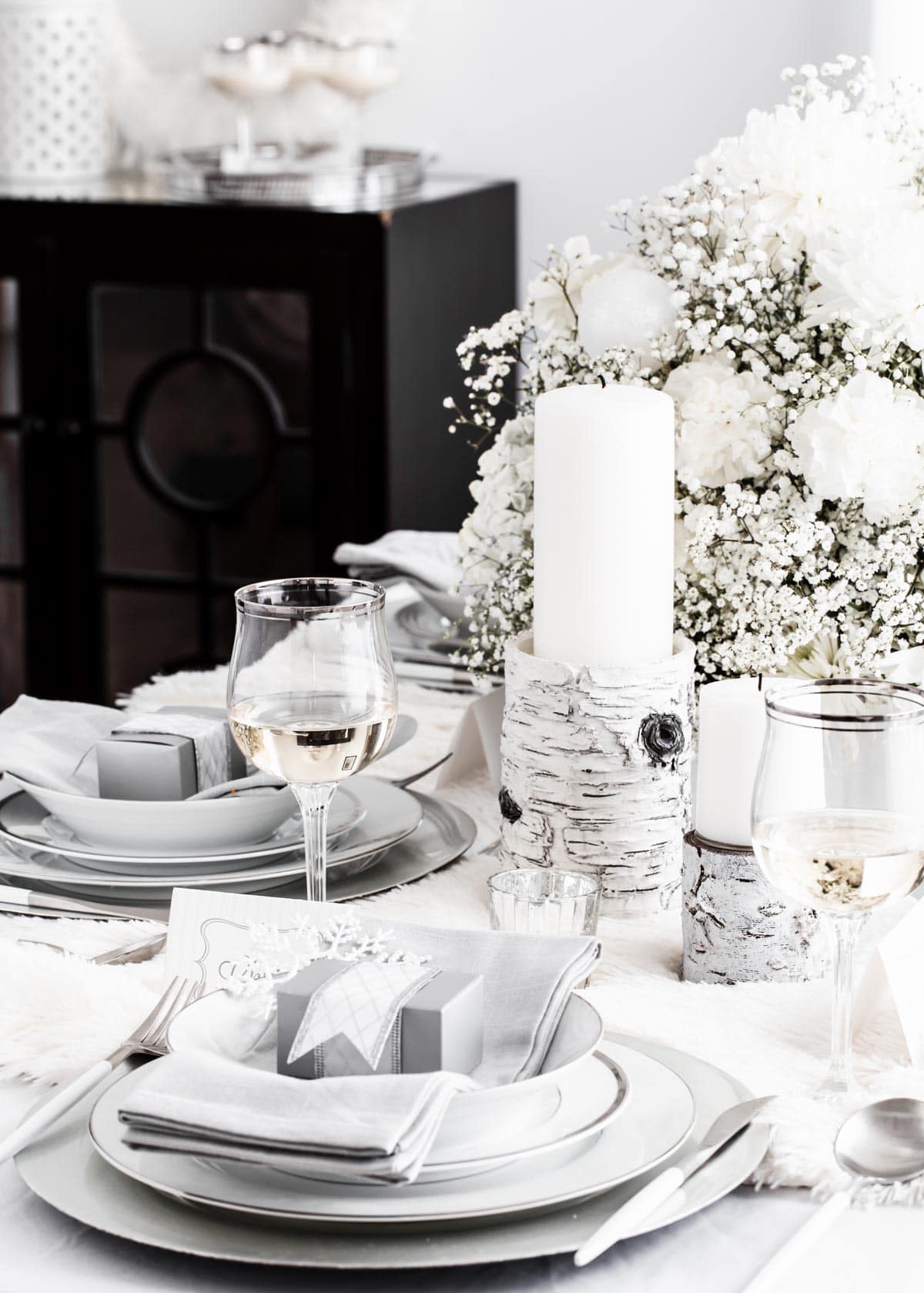 white and silver table setting for winter themed party.