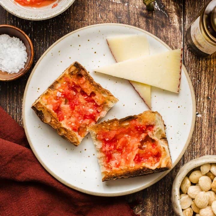 bread slices with tomato spread on top, sitting on plate with cheese slices.