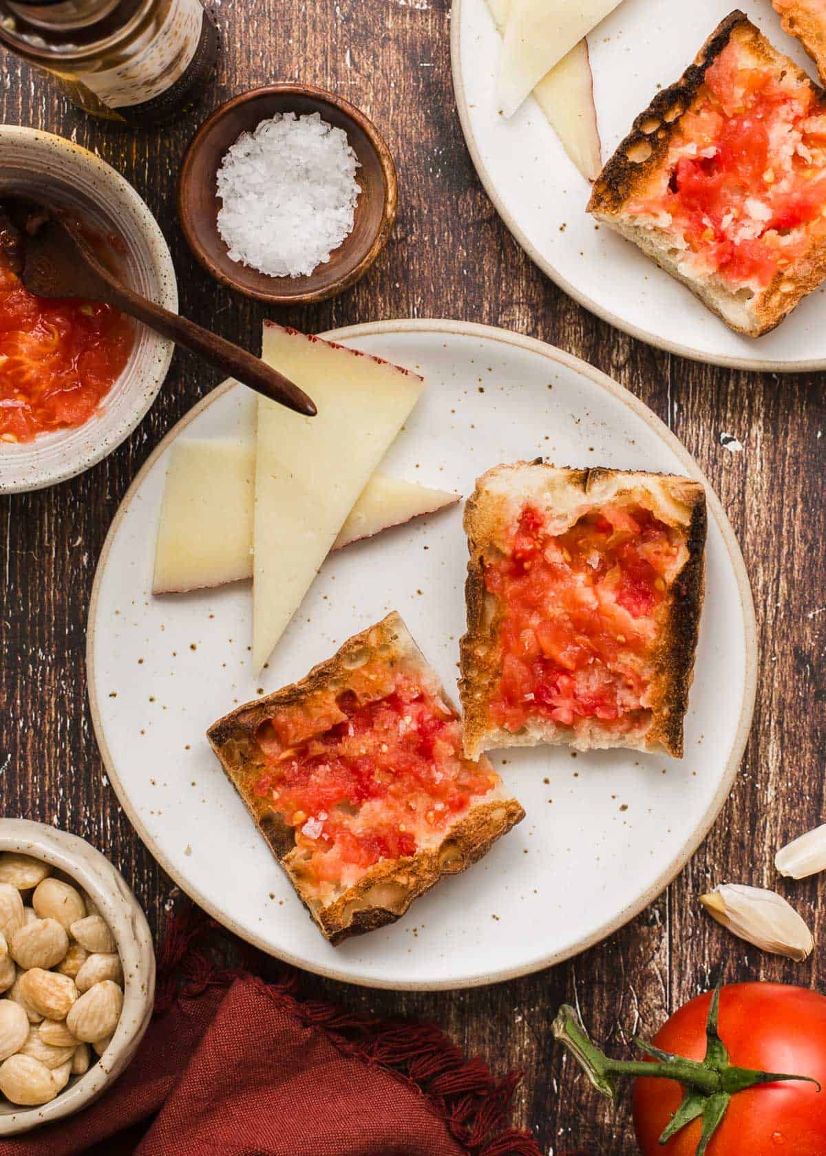 bread slices with tomato spread on top, sitting on plate with cheese slices.