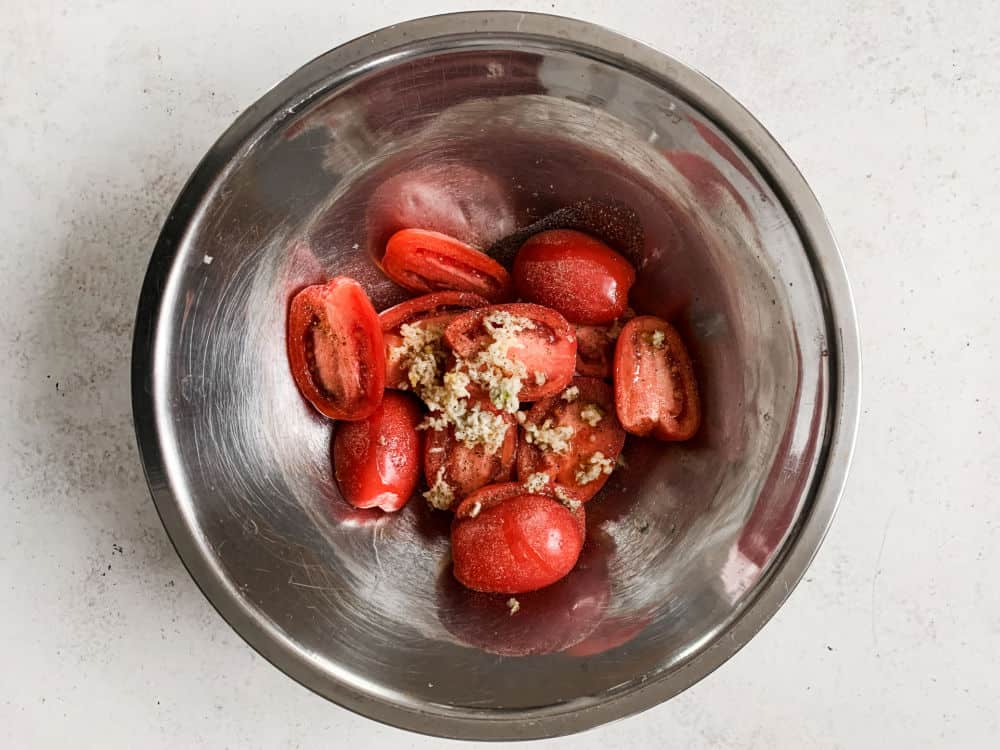 cut tomatoes in a bowl with seasoning.