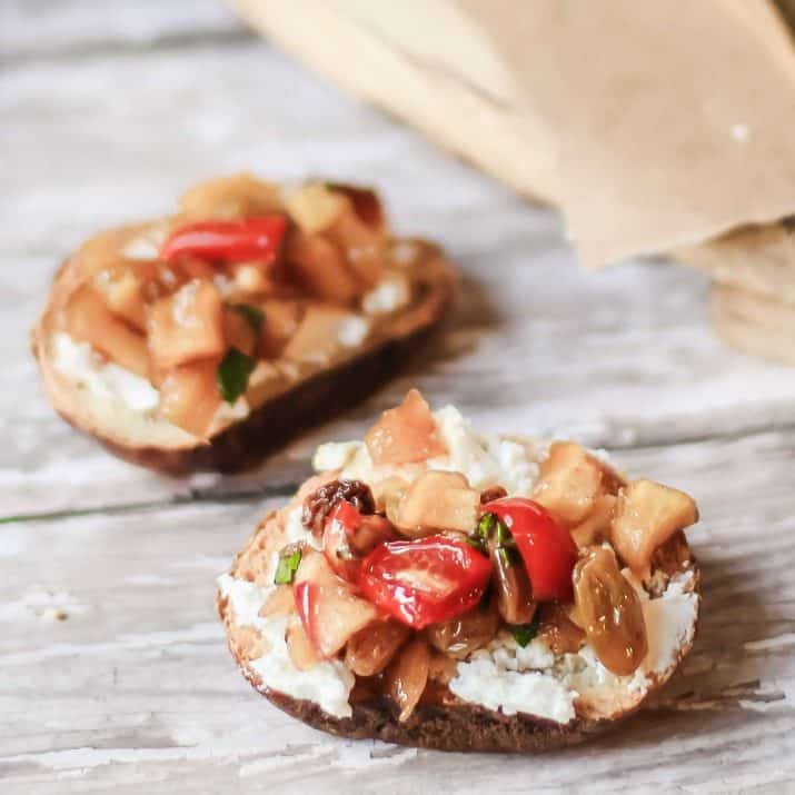 two crostini with goat cheese and apple chutney on top.