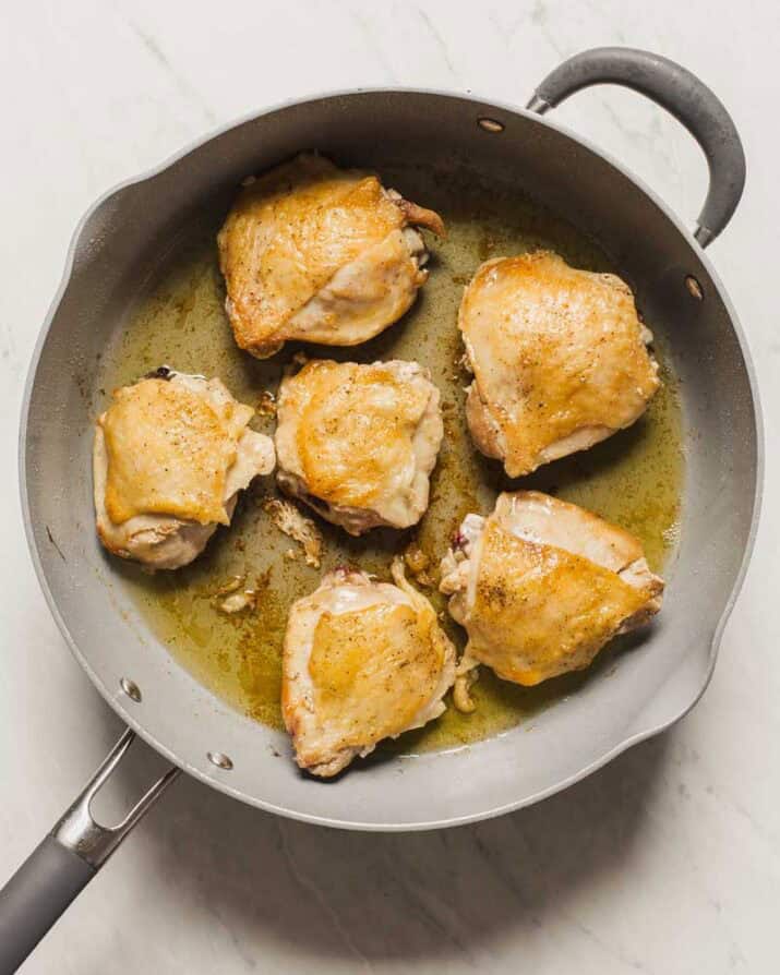 cooked chicken thighs in large skillet.