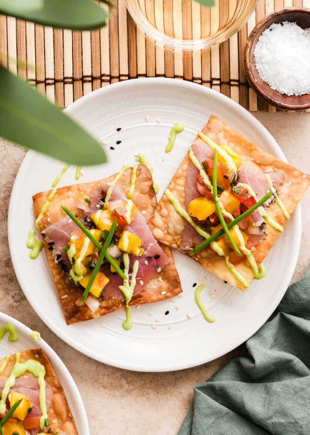 small plate with smoked ahi tuna on fried wontons, with fruit salsa on top.