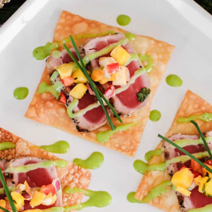 close up view of seared ahi tuna slices on fried wonton base, topped with fruit salsa.
