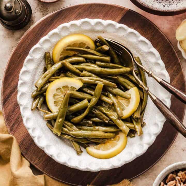 green beans with lemon slices served in white bowl.