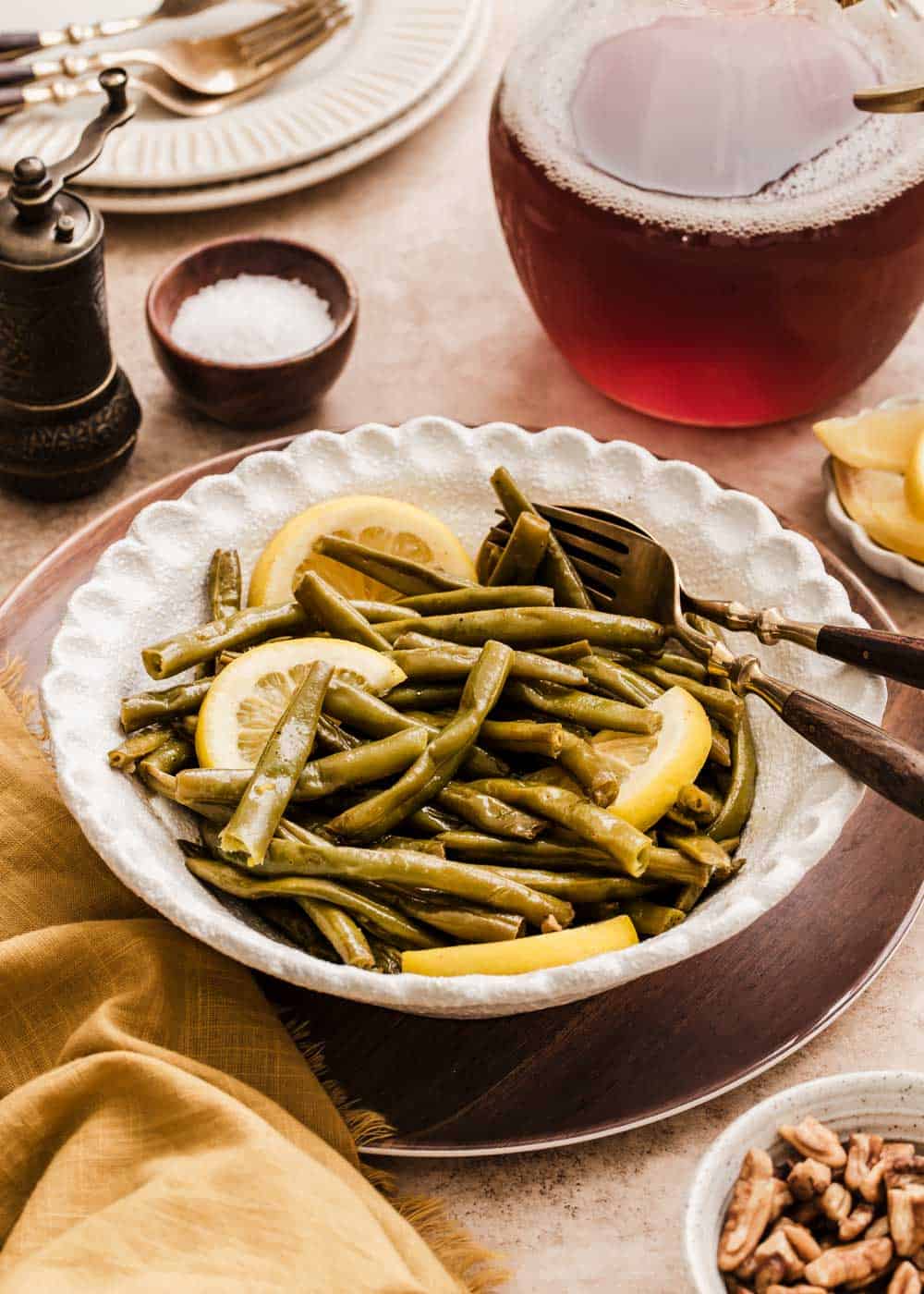 green beans with lemon slices served in white bowl on dining table.